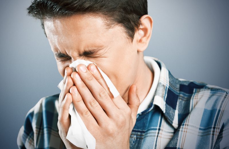Man with allergies sneezing