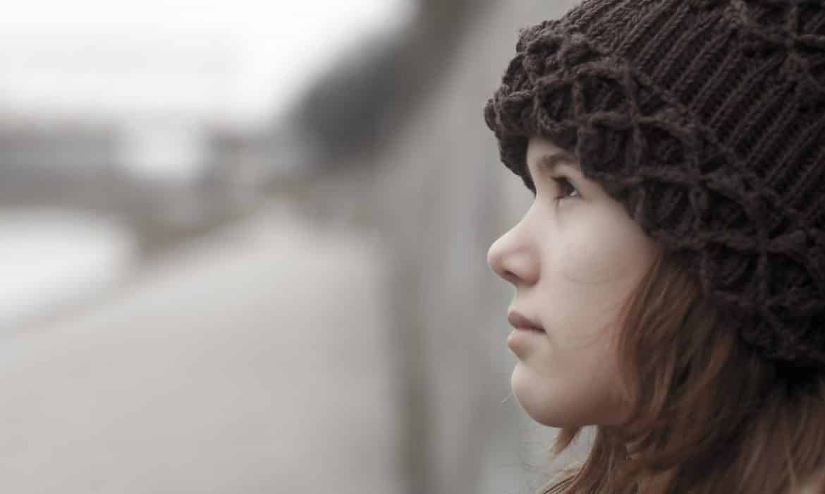 Portrait of sad teenage girl outdoor on moody autumn day.