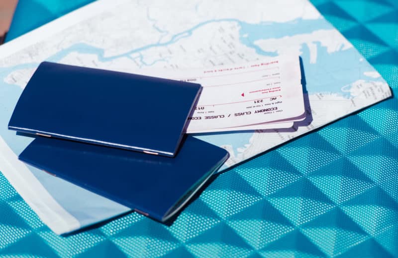 Two passports and two airline tickets sitting on top of a map