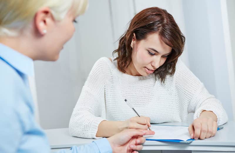 Woman completing checklist of instructions at hospital