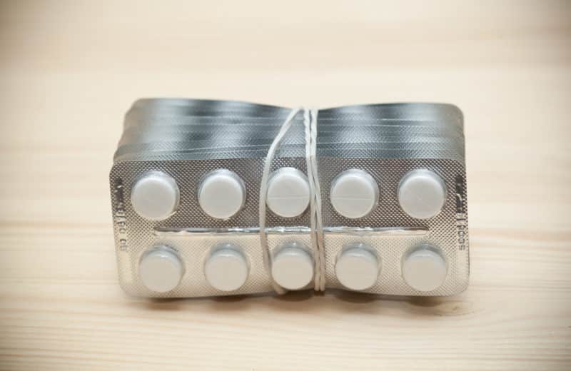 Multiple packets of penicillin tabs rubberbanded in a stack