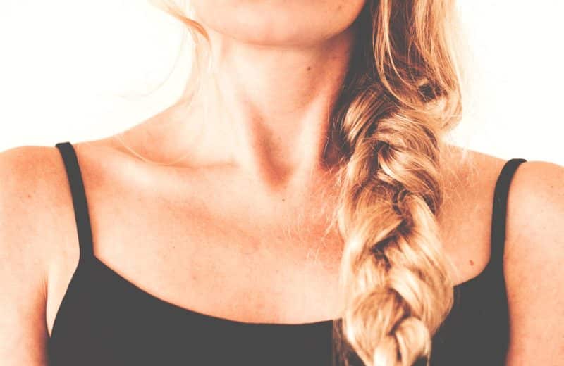 Is an underactive thyroid something to worry about? Image of chin, neck, and chest of young woman in black tank top with blond hair in a braid.