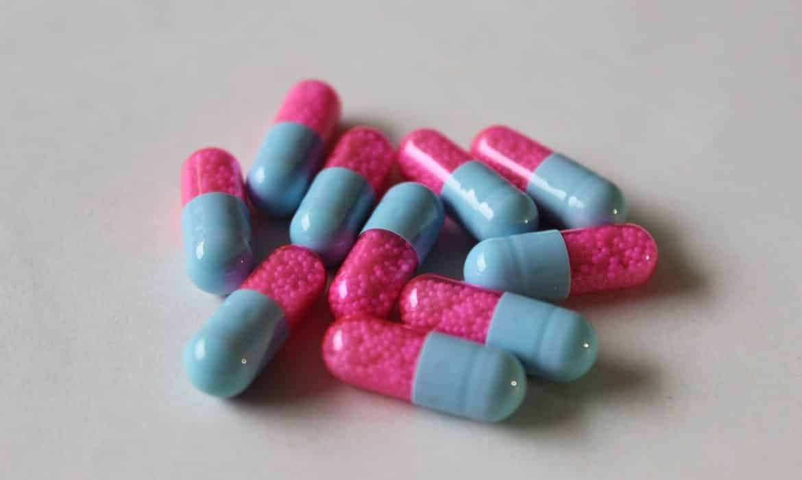 What you need to know about safely stopping antidepressants. Image is of pile of pink and blue capsules on grey table.