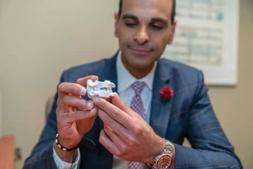 Dr. Mark Mikhael holds a model of the replacement disc.