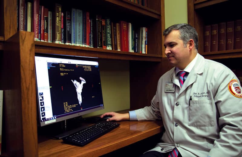 Orthopedic surgeon Dane Salazar, MD, looks at images using 3D templating software to create a digital model of the patient’s shoulder for reverse total shoulder replacement. Photo courtesy of Loyola Medicine