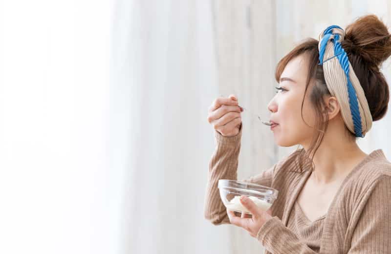 peptic ulcer prevention woman eating yogurt