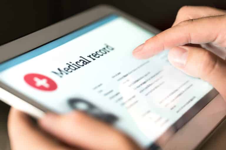 Electronic medical record with patient data and health care information in tablet. Doctor using digital smart device to read report online. Modern technology in hospital