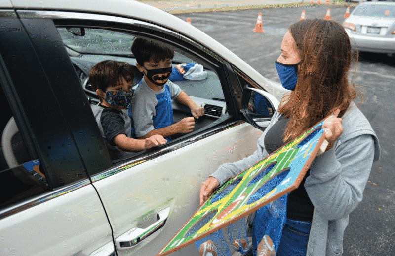Friendship Circle volunteer plays games with children during drive-thru event. Photo Courtesy of Zelik Moscowitz