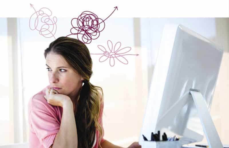 Young distracted woman with ADHD sitting at computer