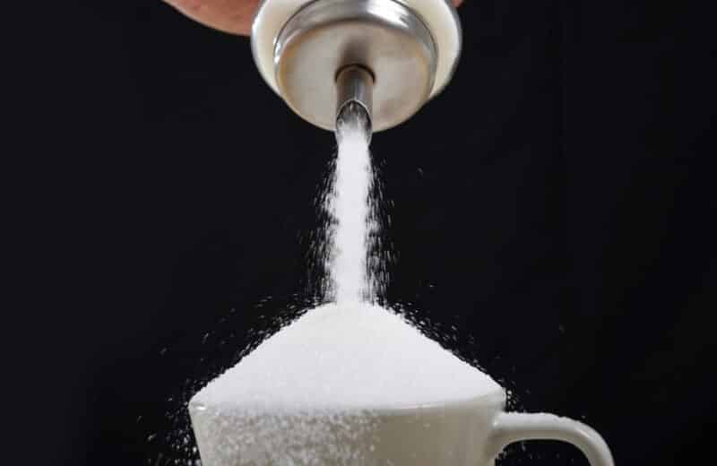 Sugar pouring into a cup, added sugar