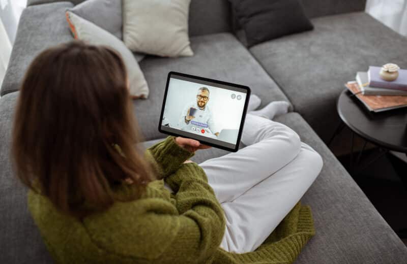 Woman receiving counseling with her therapist virtually on a tablet