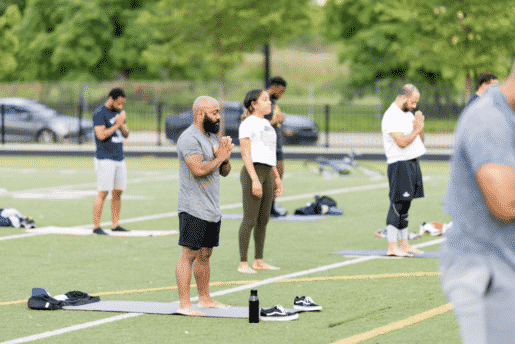 A group of people in a Chicago field practice yoga to address mental health.
