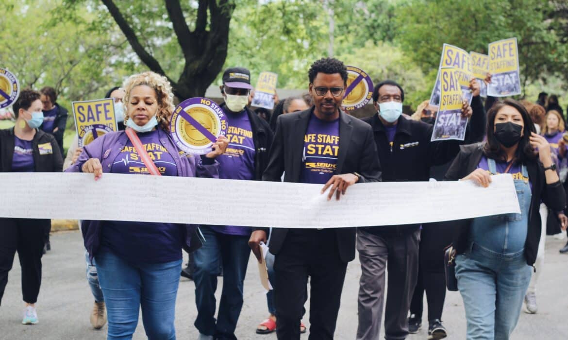 SEIU members hold an 18-foot long petition, with thousands of healthcare worker signatures