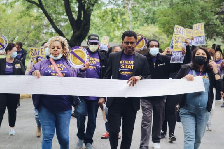 SEIU members hold an 18-foot long petition, with thousands of healthcare worker signatures