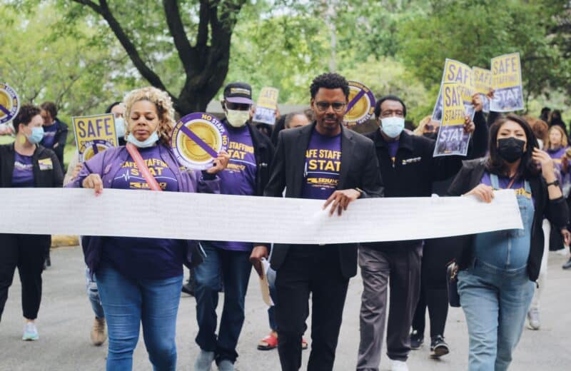 SEIU members hold an 18-foot long petition, with thousands of healthcare worker signatures