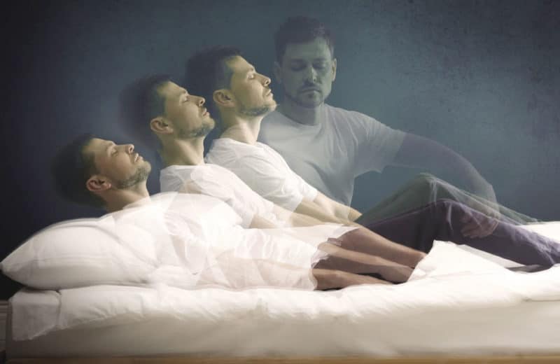 Sleep disorder. Man sitting up in bed while dreaming. Link to Parkinson's Disease.