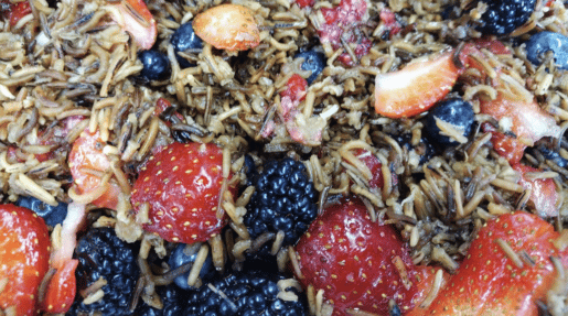 A closeup of wild rice, strawberries and blackberries