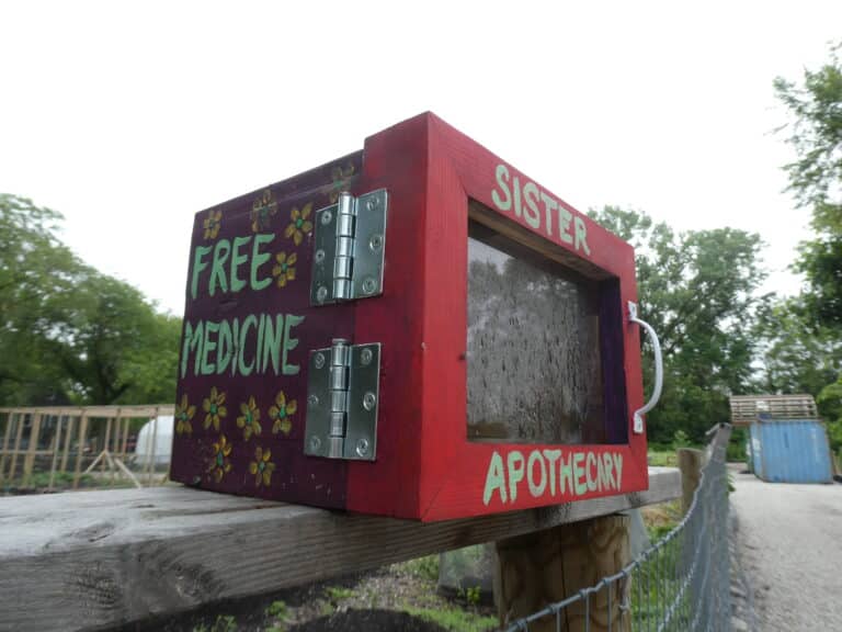 A red box sits atop a wooden fence.