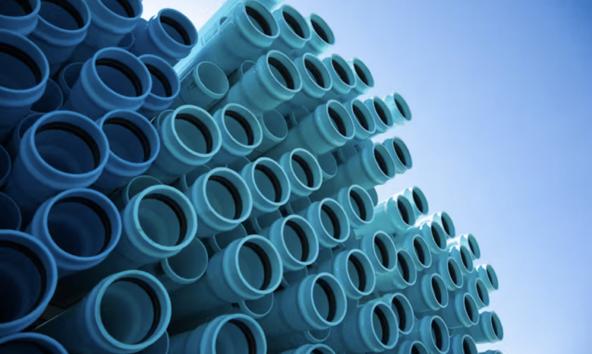 A pile of blue/green pipes reach skyward