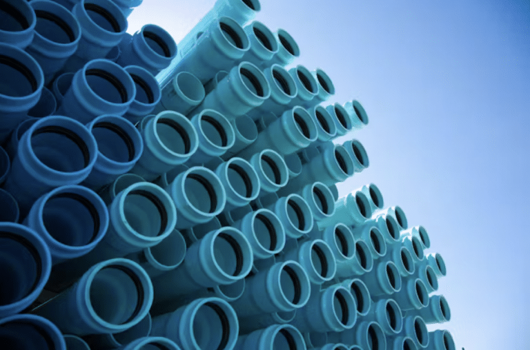 A pile of blue/green pipes reach skyward