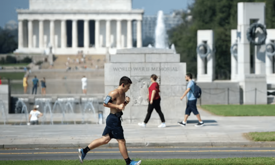 A man runs outdoors in Washington, D.C. as people walk in the background.
