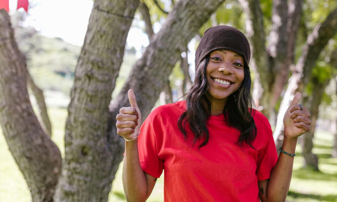 Portrait of a young woman giving a thumbs up. Her expression shows happiness, positivity and optimism