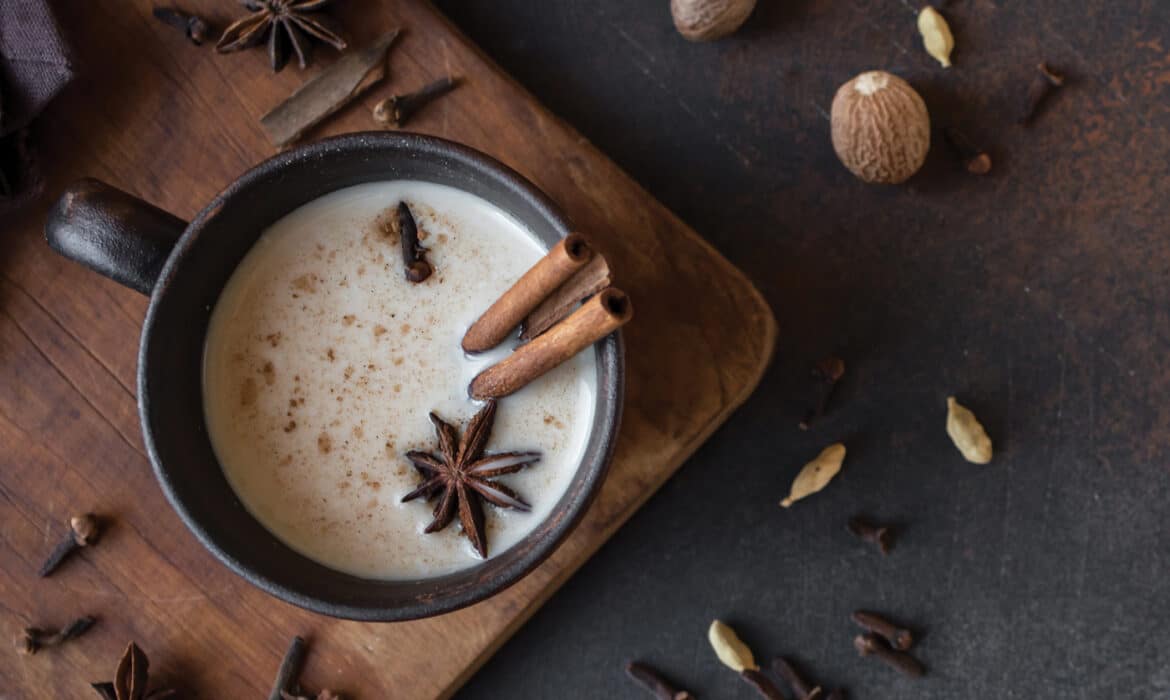 Cup of chai tea surrounded by spices