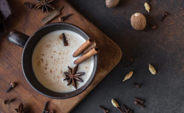 Cup of chai tea surrounded by spices