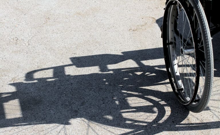 Shadow of a wheelchair representing the ongoing survival of gun violence