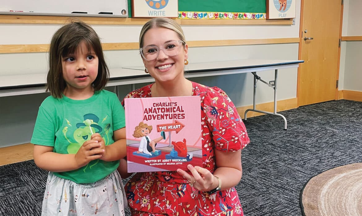 A young reader and Abby Brecking read Charlie’s Anatomical Adventure