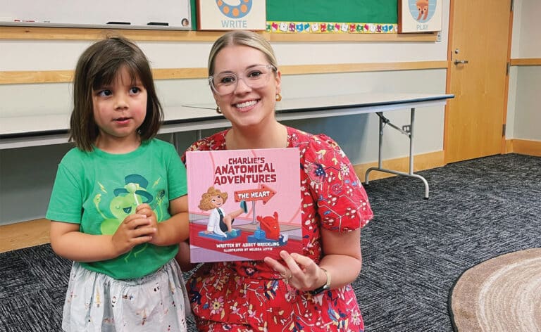 A young reader and Abby Brecking read Charlie’s Anatomical Adventure