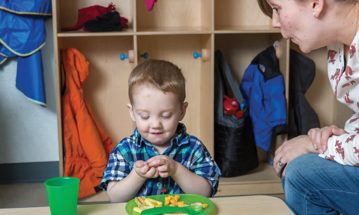 Adult attempting to get child to eat their food