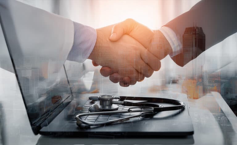 A businessman and a doctor shake hands representing private equity in healthcare