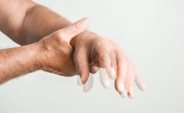 Shaking hand representing Parkinson's disease. Insurance lags in Parkinson’s-specific exercise coverage