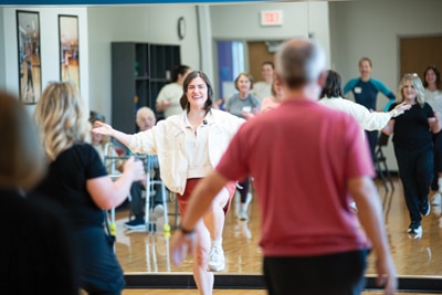 Photo of m.o.v.e. founder Erica Fenton leading a body, brain, voice warm-up. Photo by Nick Duncan Photography.