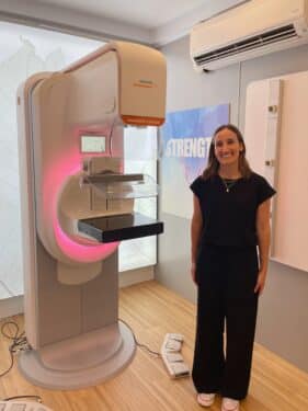 A nurse from Rush University Medical Center stands with the mammogram machine in the mobile clinic stationed at the Humboldt Park Boat House.